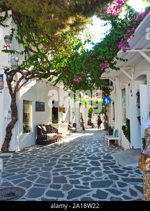 Les gens de détente confortable sur la rue pavée de la vieille ville avec des bâtiments blancs et des divans à Parikia Paros Grèce Banque D'Images