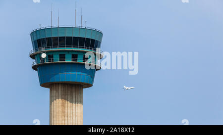Tour de contrôle de l'aéroport avec jet avion vol partira dans ciel bleu à sa destination. Banque D'Images