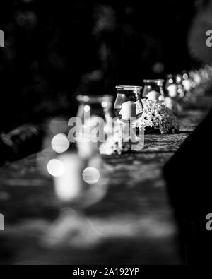 Image en noir et blanc de mariage avec fleurs blanches et de petites bougies en vase en verre Banque D'Images