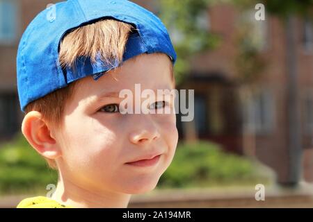 Portrait d'un garçon avec un visage sérieux expression wearing blue baseball cap Banque D'Images
