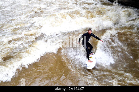 Munich / Allemagne - Juillet 13, 2019 : Surfer rides les vagues artificielles sur le site de l'Eisbach, une petite rivière à Munich. Banque D'Images