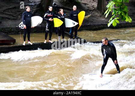 Munich / Allemagne - Juillet 13, 2019 : Surfer rides les vagues artificielles sur le site de l'Eisbach, une petite rivière à Munich. Banque D'Images