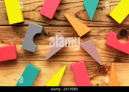 Mise à plat des chiffres en bois coloré lumineux dispersés sur des bandes brun clair, abstract background Banque D'Images