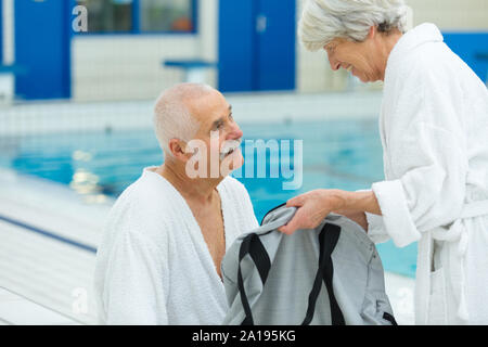 Senior couple holding hands in a swimming pool Banque D'Images