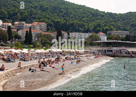 Plage de Dubrovnik ; touristes bronzant sur Sunset Beach juste à l'extérieur de la vieille ville, de la côte dalmate à la Dubrovnik Croatie Europe Banque D'Images