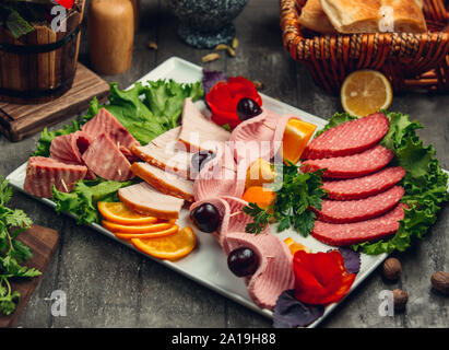 Découpe de la viande avec des olives et des tranches d'orange Banque D'Images