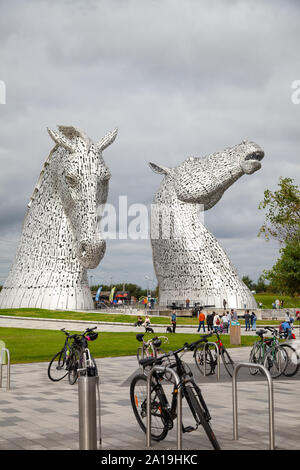 Les vélos en face de l'Kelpies 30 mètres de haut sculptures à tête de cheval au centre près de Falkirk en Écosse Helix Banque D'Images