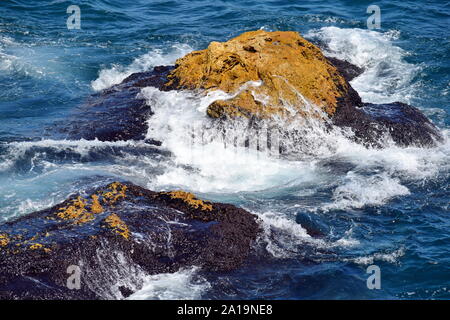 Éclaboussures des vagues de la mer sur les rochers près des falaises de roche Tyulenovo Banque D'Images