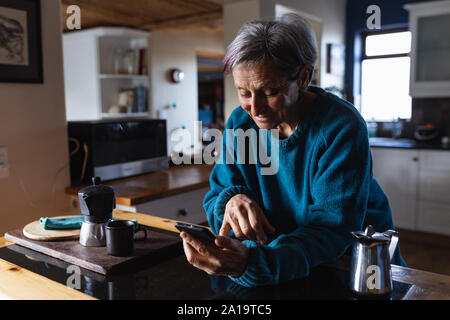 Senior woman using smartphone à la maison Banque D'Images