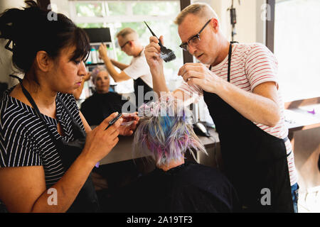 Coiffeurs et female client dans un salon de coiffure Banque D'Images