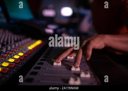 Le producteur de musique d'hommes travaillant à la table de mixage dans un studio de son Banque D'Images