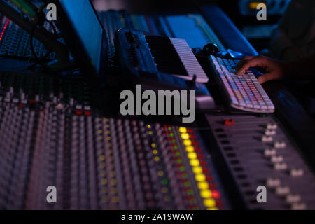 Le producteur de musique d'hommes travaillant à la table de mixage dans un studio de son Banque D'Images