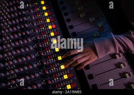 Le producteur de musique de femmes travaillant à la table de mixage dans un studio de son Banque D'Images