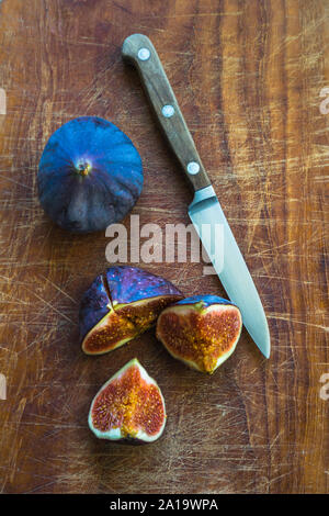 Figs sur planche de bois à l'aide d'un couteau Banque D'Images