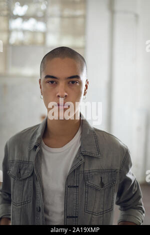 Portrait d'un jeune homme avec des piercing sur les deux oreilles et le nez, à l'appareil photo de Banque D'Images