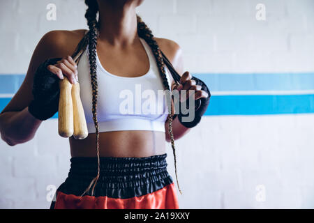 Boxer debout avec la corde à sauter dans le club de boxe Banque D'Images