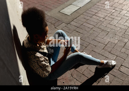 Young woman using smartphone outdoors Banque D'Images