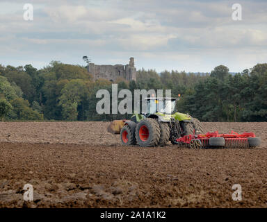 Claas Axion 850 fonctionne à nouveau Ladykirk ferme sur la frontière écossaise avec Norham Castle un peu plus le tweed en Angleterre. Banque D'Images