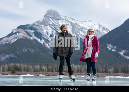 Couple patiner ensemble en paysage de neige Banque D'Images