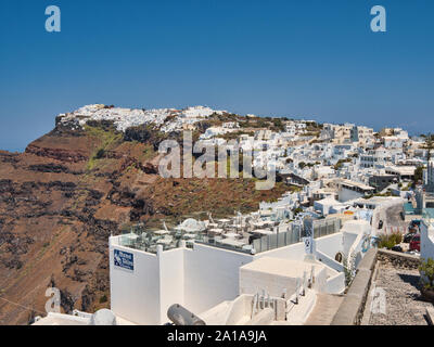 Vieille ville de montagne d'Oia avec ses maisons blanches et ses rues étroites sur l'île de Santorin en Grèce sous ciel bleu Banque D'Images