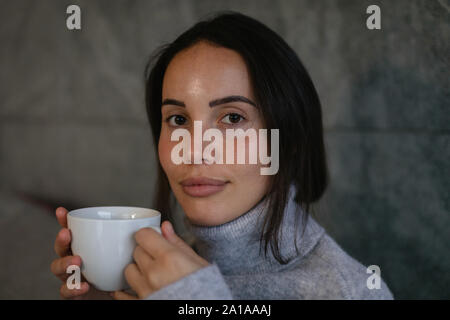 Jeune brunette woman drinking coffee Banque D'Images