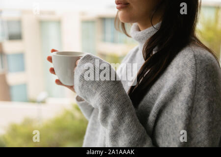 Jeune brunette woman holding a cup of coffee Banque D'Images