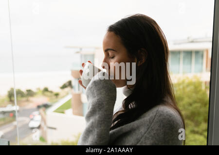 Jeune brunette woman drinking coffee Banque D'Images