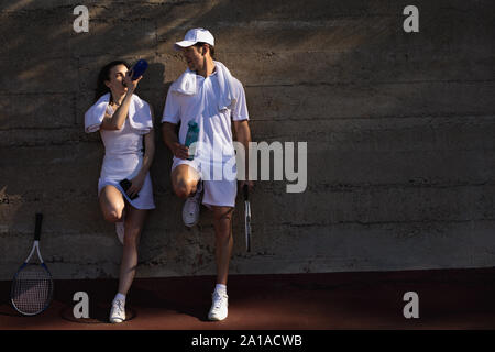 La femme et l'homme de prendre une pause pendant un match de tennis Banque D'Images