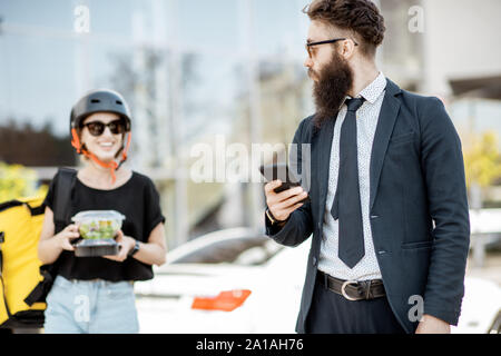 Employée de bureau en attente d'un courrier, avec commande à emporter téléphone déjeuner à un restaurant. Restaurant Frais de livraison alimentaire concept Banque D'Images