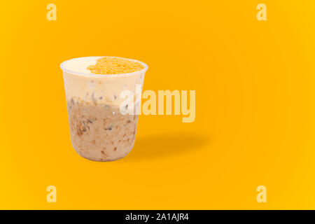 Lait glacé le thé avec des oeufs salés isolé en fond jaune. Banque D'Images