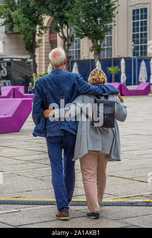 Middle-aged couple walking through city square - Vienne, Autriche. Banque D'Images
