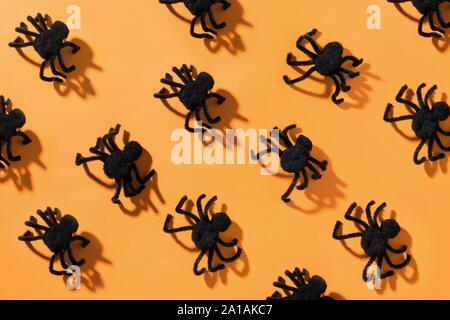 Handmade Black spiders sur fond orange. Vue de dessus. Ouvrir la composition. Halloween party. Banque D'Images