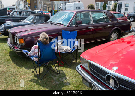 Le propriétaire d'un 1970 bourgogne Bentley saloon assise avec son chien Schnauzer l'entente au Classic Motor Show sur Walmer Green par la plage, Deal, Kent, U Banque D'Images