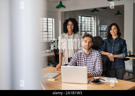 Groupe diversifié de smiling les concepteurs travaillant ensemble dans un bureau Banque D'Images