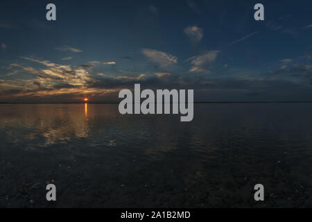 Soleil couchant sur la baie de Somme coté Hourdel. Effet miroir et reflets sur l'eau, la perspective naturelle et horizon windows wallpaper. Banque D'Images