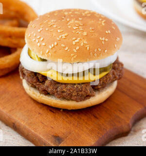 Des limaces Mississippi Burger avec des oignons sur une planche de bois rustique, vue de côté. Libre. Banque D'Images