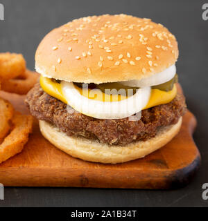 Des limaces Mississippi hamburgers avec des oignons sur une planche en bois rustique sur un tableau noir, vue de côté. Libre. Banque D'Images