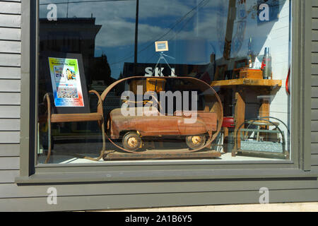 Vieilles et rouillées petite voiture pédale affichée dans la fenêtre d'une boutique d'antiquités dans le New Hampshire, USA. Banque D'Images