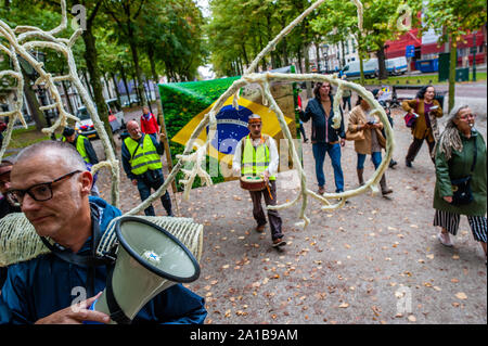 Les manifestants à pied avec une bannière brésilienne pendant la manifestation.Après l'artiste d'Arnhem, Rob Voerman a ouvert une pétition pour sauver l'Amazonie et de cesser d'Bolsonaro ce qui a déjà été signé plus de 8 100 fois, il a organisé une manifestation avec d'autres partisans de La Haye contre la politique du président brésilien, Bolsonaro Jaďr, et contre le traité de libre-échange du Mercosur. Après la démonstration d'une pétition a été offert à l'ambassadeur du Brésil et Sigrid Kaag, ministre du Commerce extérieur et de la coopération au développement. Banque D'Images