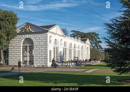 Les gens boire et manger à des tables à l'extérieur de l'Orangerie à Royal Botanic Gardens, London TW9 3AB, (Kew) Banque D'Images