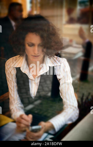 Businesswoman en utilisant son portable dans un café. Banque D'Images