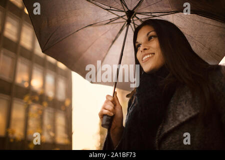 Jeune femme au travail à pied, un jour de pluie. Banque D'Images