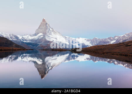 Paysage pittoresque avec le lever du soleil sur le lac Stellisee colorés. Snowy Matterhorn Cervino en crête avec reflet dans l'eau claire. Zermatt, Alpes Suisses Banque D'Images