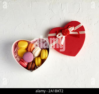 Ouvrir boîte en carton avec un dessert au four rond multi-couleurs macarons, vue du dessus, fond blanc Banque D'Images