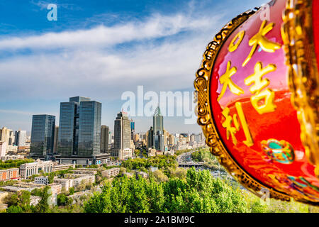 De pittoresques rues Urumqi avec lampe chinoise et gratte-ciel en arrière-plan à la fin de l'après-midi Banque D'Images