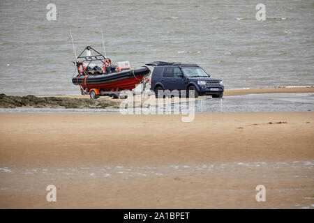 Un Land Rover Discovery accrochée jusqu'à un bateau de vitesse pas le sable à New Brighton Beach waterfront Banque D'Images