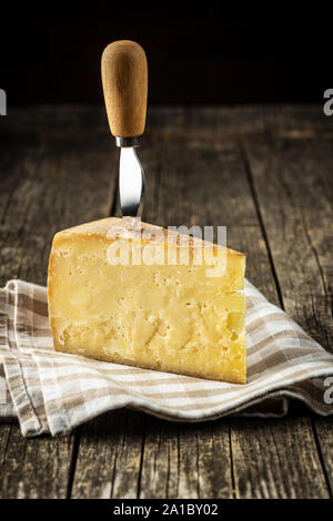 Bloc de fromage savoureux sur la vieille table en bois. Banque D'Images