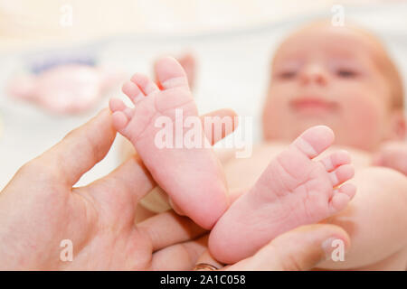 Père du bébé nouveau-né est de 30 mètres. Petites Jambes dans la main de l'homme Banque D'Images