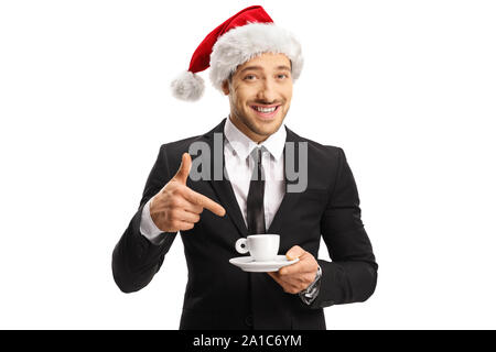 Homme en costume avec un chapeau de Père Noël tenant une tasse de café et de pointage isolé sur fond whote Banque D'Images