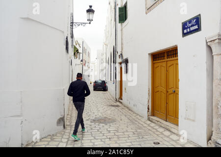 Un jeune homme tunisien de marcher dans les rues piétonnes de la Hafsia quart de la médina (vieille ville) de Tunis, Tunisie. Banque D'Images